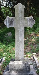 Traditional style cross gravestone in a cemetery in the forest