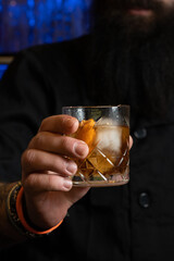 Bearded man holding iced alcoholic drink