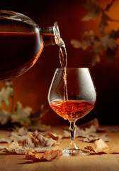 Cognac is poured into a glass from a bottle.