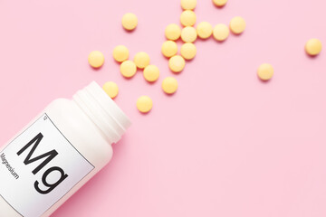 Bottle of magnesium pills on pink background