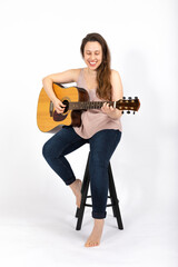 Young woman playing guitar on white background