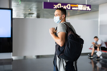 Man wearing disposable medical mask in airport during coronavirus pneumonia outbreak. Protection and prevent measures while epidemic time.