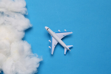 Passenger plane with a cloud on a blue background. Travel concept