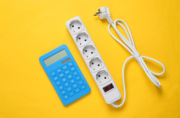 Electrical Extension cord and calculator on yellow background. Top view. Flat lay
