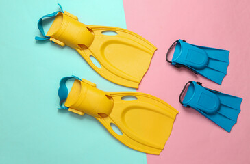 Adult and child diving fins on blue pink background. Top view © splitov27