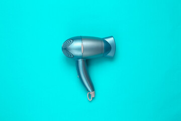 Hair dryer on blue background. Minimal beauty layout. Top view