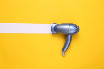 Hair dryer with white line on yellow background. Minimal beauty layout. Top view. Flat lay