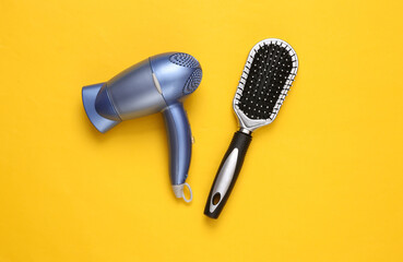 Hair dryer and hair brush on yellow background. Minimal beauty layout. Top view. Flat lay