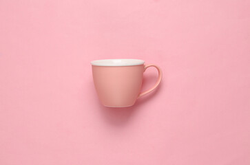 Empty cup on pink pastel background. Top view