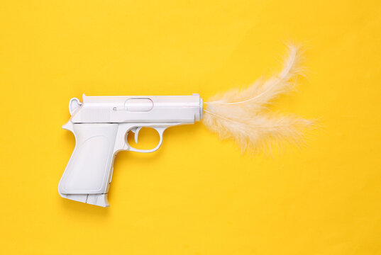 Minimal layout. White gun with feathers on yellow background.