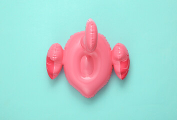 Inflatable pink flamingo on a blue background. Top view