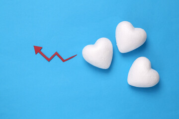Hearts with an arrow of growth on a blue background. Love statistics, analytics