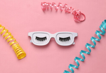 Party concept. Glasses with eyelashes and serpentine on a pink background