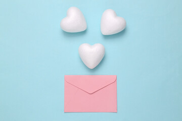 Love letter. Envelope with white hearts on blue pastel background