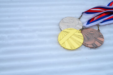 Medal set, trophy for winners in winter sport, snow in background
