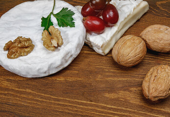 A circle of camembert cheese lies on a wooden board.
