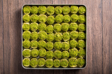 baklava whit pistachio in tray on the wooden table