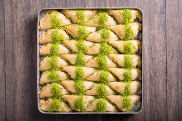 baklava with pistachio in tray
on the wooden table