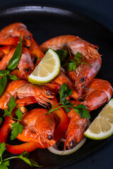 A plate with king prawns served with fresh lemon and parsley leaves