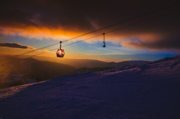 Ski lift cabine in ski resort. Sunrise light in background. Orange edit space for your montage.