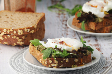 Homemade sandwiches with pesto, green salad and poached eggs