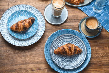 croissants with a cup of coffee on a wooden table.