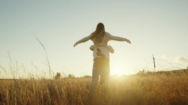 Giovane coppia di ragazza e ragazzo che ballano allegramente in campagna al tramonto