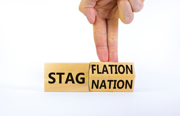 Stagflation or stagnation symbol. Businessman turns cubes, changes the word stagnation to stagflation. Beautiful white table, white background, copy space. Business, stagflation or stagnation concept.