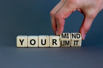 Your mind is limit symbol. Businessman turns cubes and changes words your mind to your limit. Beautiful grey table, grey background, copy space. Business, your mind is limit concept.