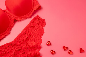 Valentine's Day background with beautiful female lacy panties, bra and hearts. Sexy underwear. Free space for text, copy space. Postcard, greeting card design. Love, celebration concept.