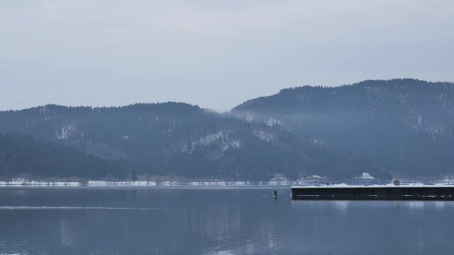 Video of Lake Yogo, Shiga Prefecture, in the dead of winter, with the surrounding area covered in white snow, a frozen landscape.