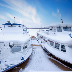 motor ships in winter parking covered with snow on the river