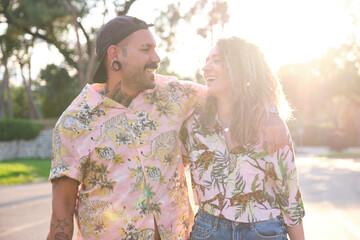 Young cool tattooed couple laughing and walking together.