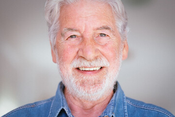 Close up portrait of beautiful senior bearded man smiling looking at camera