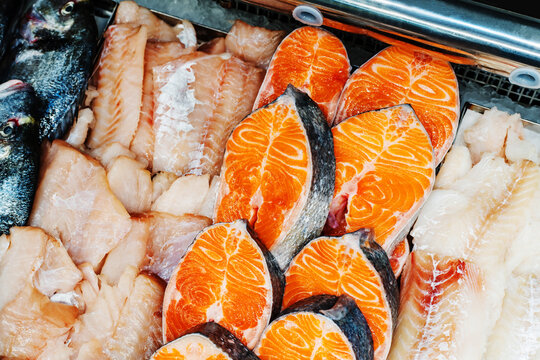 Pieces of salmon on the counter in the store. Retail trade in fresh seafood. Close-up