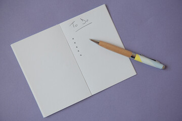 Liste de choses à faire écrite à la main dans un cahier ouvert avec un stylo sur fond mauve - to do list - obrazy, fototapety, plakaty