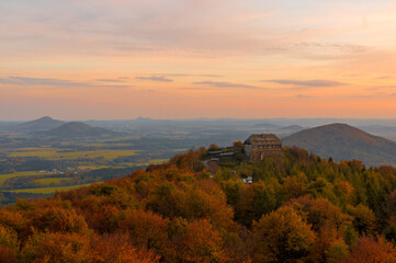 Fototapeta na wymiar Sonnenuntergang im Herbst auf dem Hochwald im Zittauer Gebirge mit Haus und Laub und Bäumen