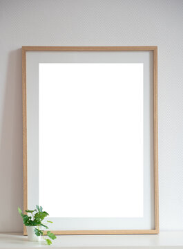 Mock up de cadre en bois sur une étagère avec une petit plante verte et mur blanc © Pause Papote