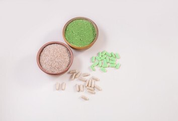 Obraz na płótnie Canvas healthy food supplements psyllium and chlorella in capsules and powder. top view