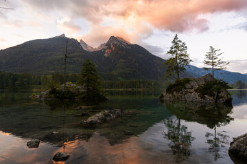 Fototapeta na wymiar Sonnenaufgang am Hintersee in den Alpen in Deutschland Bayern mit Spiegelung der Berge im Wasser 