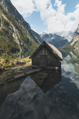 Haus am See mit Spiegelung und Berge am Obersee Königssee in den Alpen Bayern Deutschland