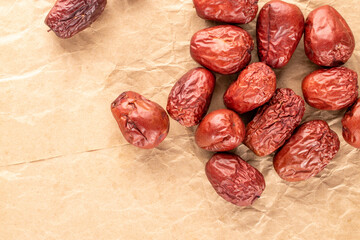 Several sweet dried ziziphus berries on craft paper, close-up, top view.