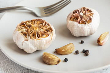 Roasted garlic on a grey plate