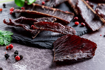 Slices of jerky meat on a dark backdround
