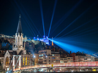 Fototapeta na wymiar Les illuminations de Fourvière à Lyon, avec jeux de lumières par projecteurs de couleurs éclairant le ciel nocturne. 