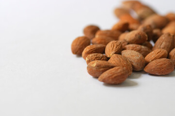 Heap of almond nuts isolated on white background