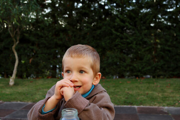 A blond boy with big eyes and an open mouth looks into the distance. Four year old boy with a surprised look  