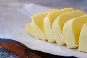 close up of slice of butter on a chopping board 