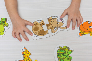 The hands of a child playing with puzzles. Early education, development.