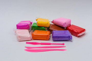 Packages of different colorful plasticine on white background.